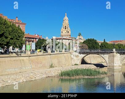 The River Segura winds its way through the ancient city of Murcia, Spain. The tower in the background is part of Murcia's cathedral. Stock Photo