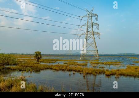 Electric power transmission is the bulk movement of electrical energy from a generating site, such as a power plant, to an electrical substation. Stock Photo