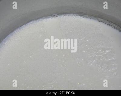 Boiling water in milk pan on gas stove Stock Photo - Alamy