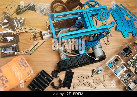 Programming classes theme. Robotic school background. Robot on table with parts around Stock Photo