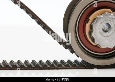 Toothed timing belt with roller close up view isolated on white background Stock Photo