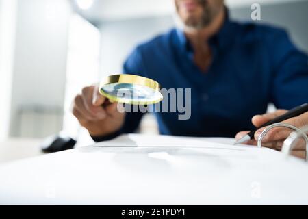 Fraud Detective Using Magnifying Glass Or Loupe Stock Photo