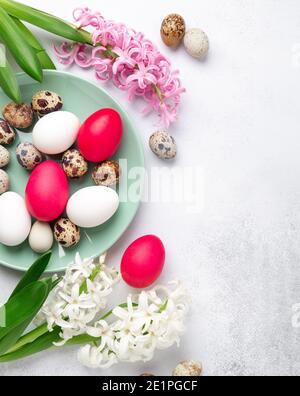 Easter composition. Green mint plate, easter eggs, pink and white hyacinth on stone background. Copy space. Top view - Image Stock Photo
