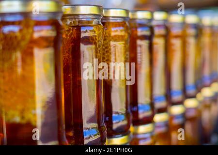 honey with honeycomb in jars stocked on a shelf Stock Photo