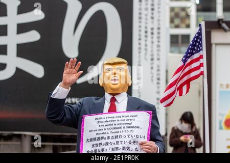 29 December 2020 - Tokyo, Japan: A Donald Trump supporter, wearing a rubber mask, protests the US Election, just weeks before Trump supporters in the Stock Photo