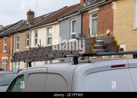 A set of ladders on the roof of a builders van Stock Photo