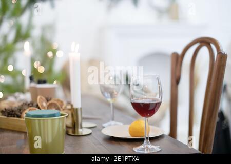 Festive Christmas atmosphere at home in a Scandinavian-style room on a table with candles and a Christmas tree. Stock Photo