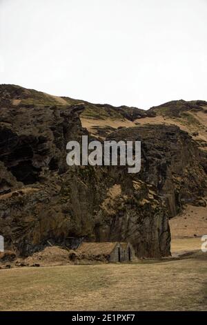 Panorama of Drangurinn i Drangshlid boulder rock formation historical landmark turf house building in South Iceland Europe Stock Photo