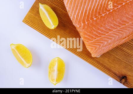 Raw fillets salmon in wooden cutting board on white background Stock Photo