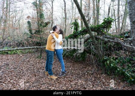 Happy young couple hugging and laughing in beautiful forest.Romantic love story , friendship lifestyle.Travel concept.