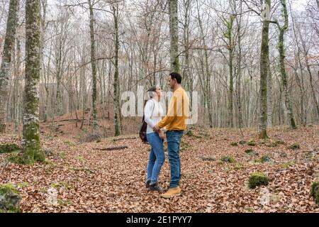 Beautiful couple talking and giving hands in forest.Love Romantic concept and friendship lifestyle .Travel with couple or friends.