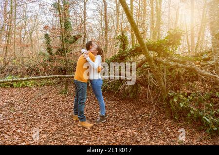 Beautiful young couple hugging in autumnal forest at sunset.Romantic , love and friendship lifestyle.Travel concept.