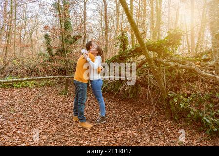 Beautiful young couple hugging in autumnal forest at sunset.Romantic , love and friendship lifestyle.Travel concept. Stock Photo