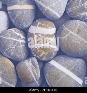 Smooth striped stones on the beach. Stock Photo
