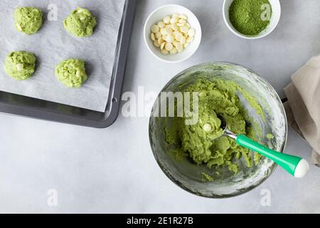 dough with matcha green tea and baked sheet with raw cookies Stock Photo