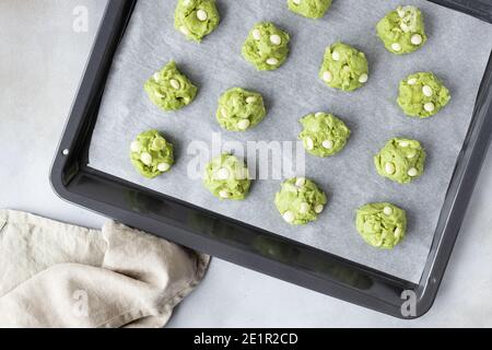 matcha green tea cookie dough balls on baking sheet Stock Photo