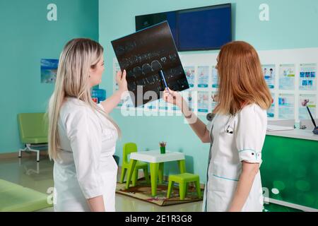Two doctors looking at x-ray image on screen in clinic Stock Photo
