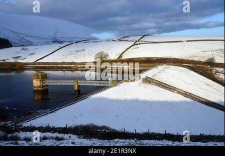 Man Walking on Lower Ogden Reservoir Dam near the Village of Barley from Path to Pendle Hill in Ogden Clough, Lancashire. UK. Stock Photo
