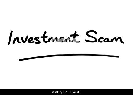 Investment Scam handwritten on a white background. Stock Photo