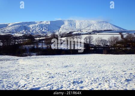 Pendle Hill and Snow Covered Fields near Lower Black Moss Reservoir Dam in Winter near the Village of Barley, Pendle, Lancashire. UK. Stock Photo
