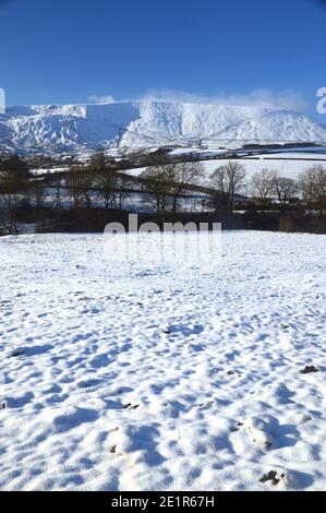 Pendle Hill and Snow Covered Fields near Lower Black Moss Reservoir Dam in Winter near the Village of Barley, Pendle, Lancashire. UK. Stock Photo