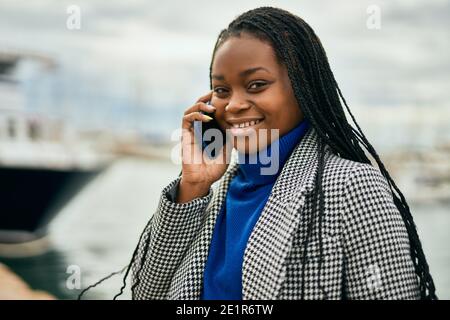 Young african american businesswoman smiling happy talking on the smartphone at the port. Stock Photo
