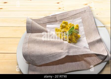 ravioli del plin typical Piedmontese stuffed pasta from the Langhe seasoned with butter and sage and parmesan, traditionally served in a napkin Stock Photo