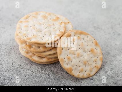Stack of various organic crispy corn crackers with sesame and salt on light background. Stock Photo