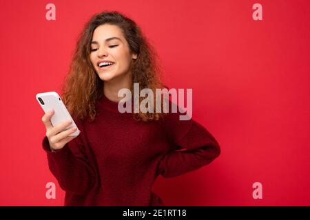 Photo shot of attractive positive good looking young woman wearing casual stylish outfit poising isolated on background with empty space holding in Stock Photo