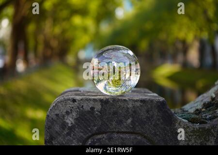 The beautiful green city canal (Kö-Graben) on Königsallee with reflection of the scenery in a glass ball. Stock Photo