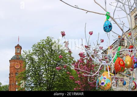 VINNYTSIA, UKRAINE - APRIL 29, 2019: Top view of old fire tower with clock (1911), sakura tree and Easter eggs Stock Photo