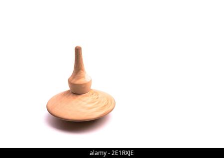 Close up shot of a wooden spinning top moving on white background, isolated Stock Photo