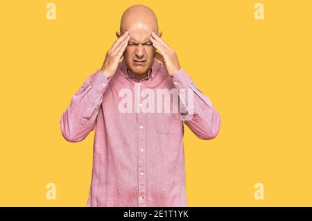 Middle age bald man wearing casual clothes with hand on head for pain in head because stress. suffering migraine. Stock Photo