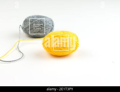 Threads for knitting fashionable sweaters.Yellow and gray ball of woolen thread on a white background. Illuminating and Ultimate Gray. Color of the ye Stock Photo