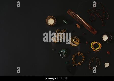 Occult symbols laid out on a black background. Aroma stick, Ganesha figurine, stone rosary. Stock Photo