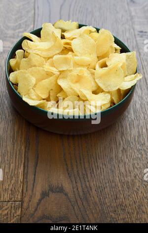 Large wood bowl of crispy Kettle potato chip snack on hardwood planks Stock Photo