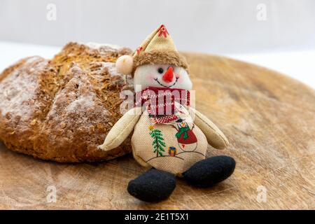 Wholemeal bread Christmas doll snowman on a brown background. Stock Photo