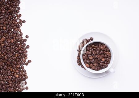 top view of White cup filled with freshly roasted coffee beans isolated on white background Stock Photo