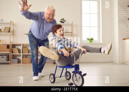 Happy grandfather and grandson playing together and having fun on weekend at home Stock Photo