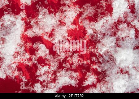 Abstract red and white natural background. Snow flakes on a red background close-up. Stock Photo