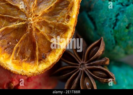 Spices and candied fruits close-up. Star anise and dried orange on the background of colorful cookies. The concept of the winter food Stock Photo