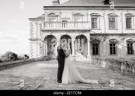 Bride and groom standing in front of each other and embracing. Black and white  Stock Photo