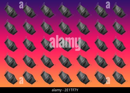 Protective mask pattern. Face protective masks pattern isolated on gradient background. Many black medical masks on the multicolored background. Medic Stock Photo