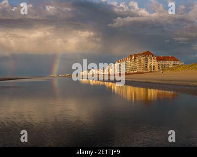 Colorful rainbow at the beach under dramatic sky Stock Photo