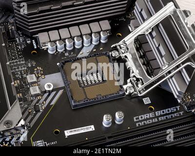 Varna, Bulgaria, January 06, 2021. Processor socket with gold plated contacts on a modern black motherboard. Computer mainboard circuit components. Stock Photo