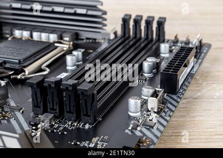 Four slots for ddr4 ram memory modules on a modern black pc motherboard. Computer mainboard circuit components. Desktop hardware close-up. Stock Photo