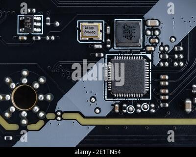 Circuit board with microchips and other electronic components on a modern black motherboard. Computer mainboard circuit components. Desktop hardware Stock Photo
