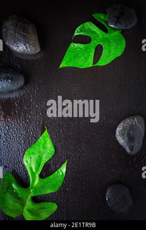 Flat lay composition with spa stones, palm leaves on grey background ...