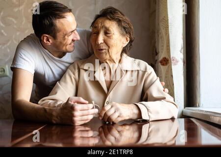 a very old woman and an adult grandson Stock Photo