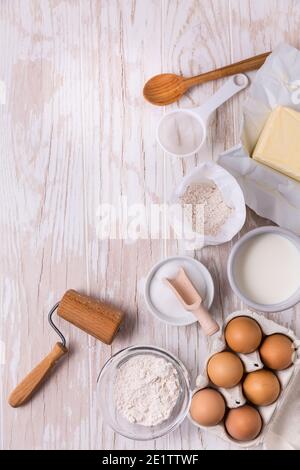 Assorted baking ingredients and kitchen utensils for cooking and baking on wooden background Stock Photo